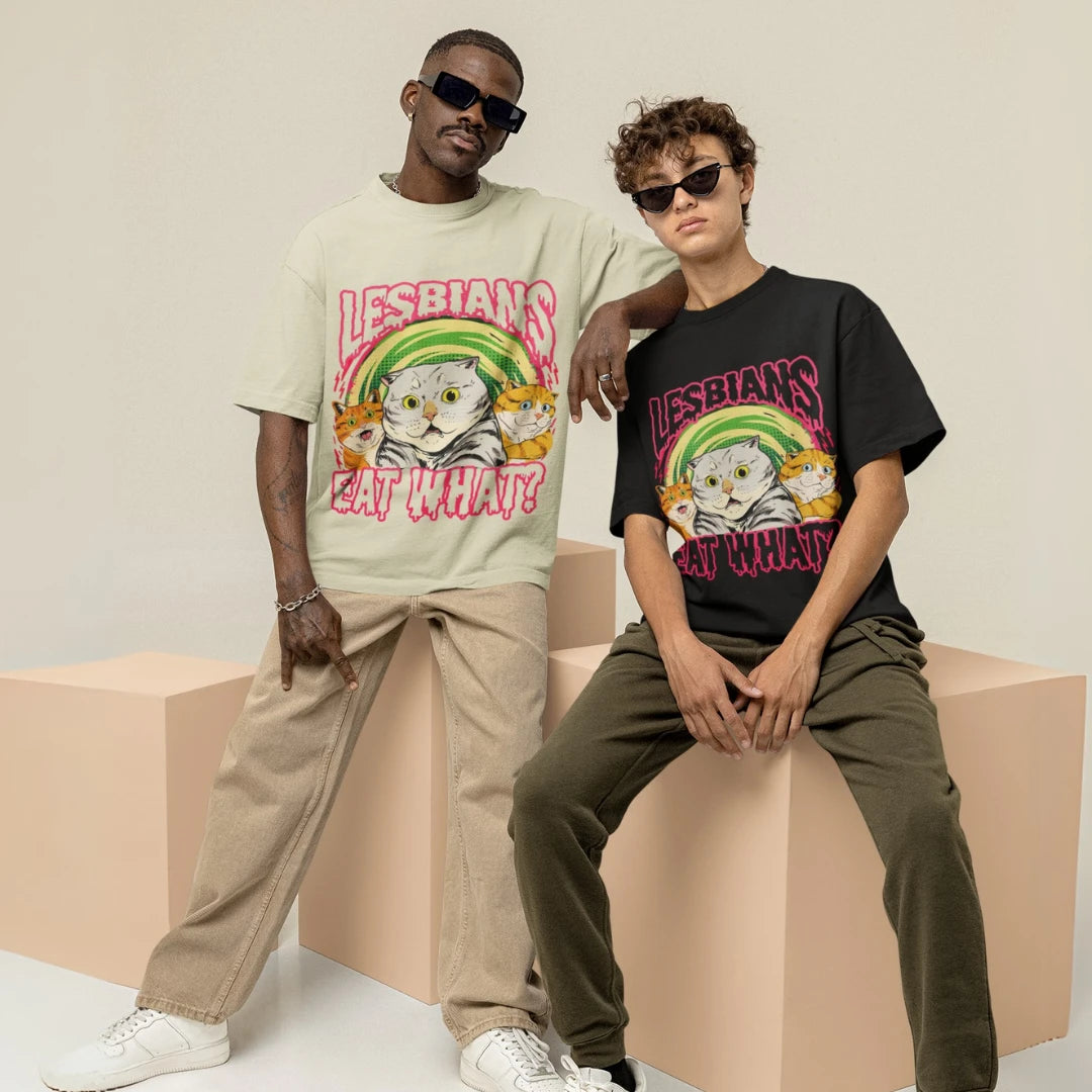 Two people wearing t-shirts with a graphic design and text, sitting on a beige block.